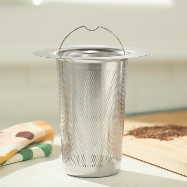 Stainless steel infuser basket on counter top.